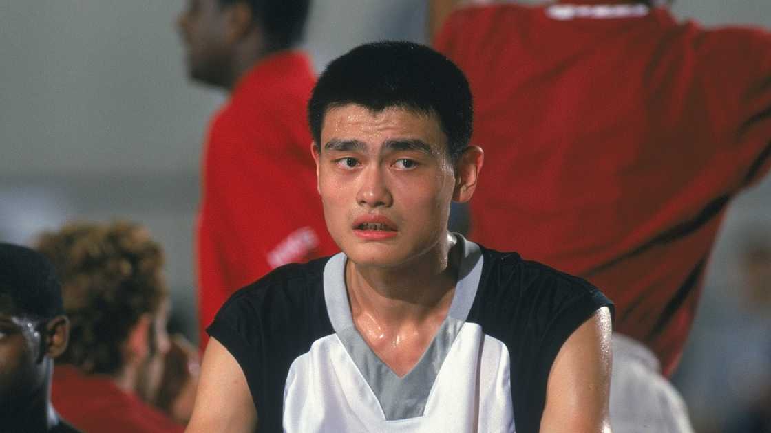 Yao Ming sits on the sidelines during a game