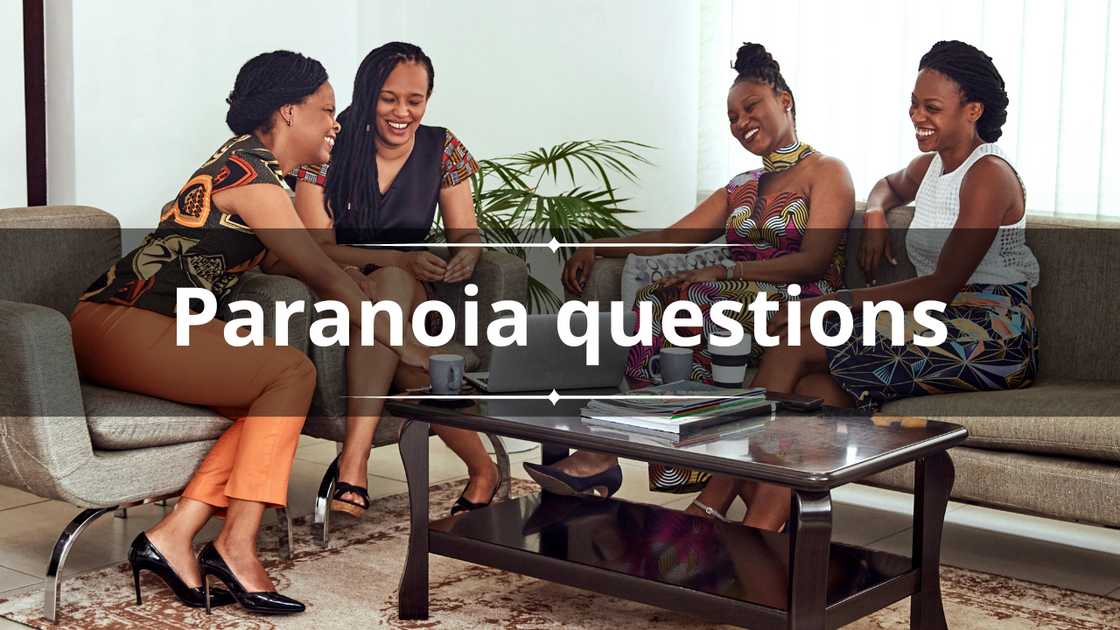 A group of women in colourful outfits is laughing during a meeting in a living room