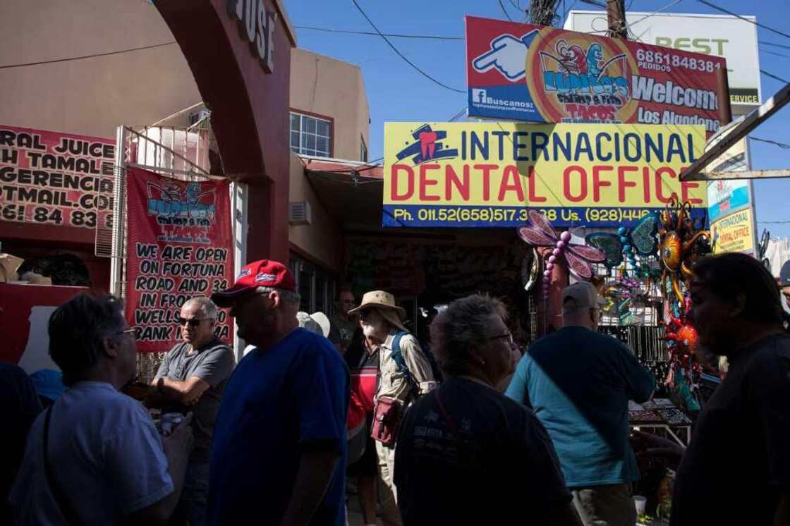 Visitors from the United States walk past a dental office in downtown Los Algodones, near the US-Mexico border in 2017