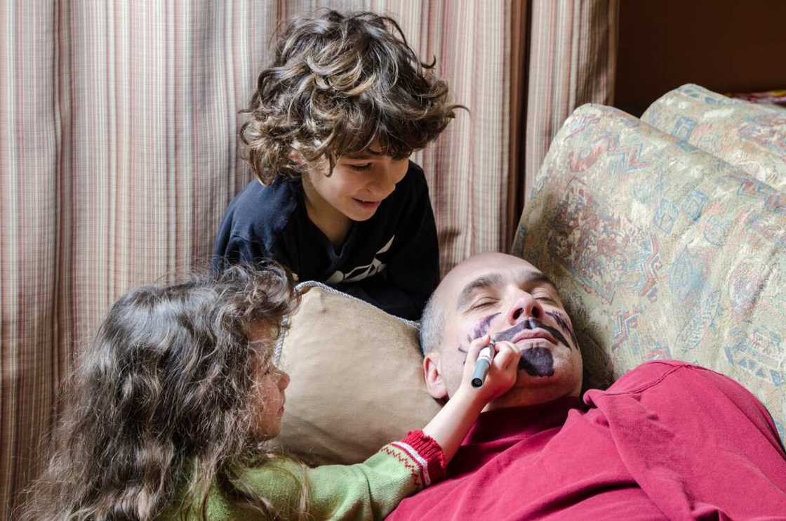 Kids drawing a mustache on father's face on April Fools' Day Kids drawing a mustache on father's face on April Fools' Day