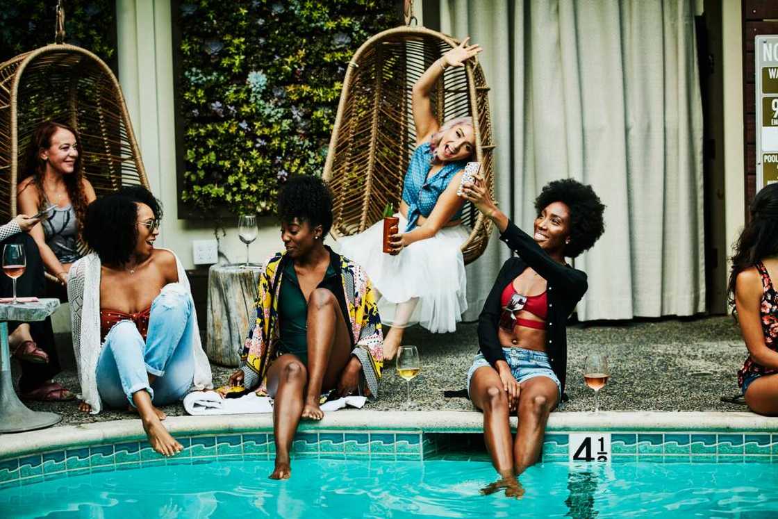 Women friends sitting beside the pool