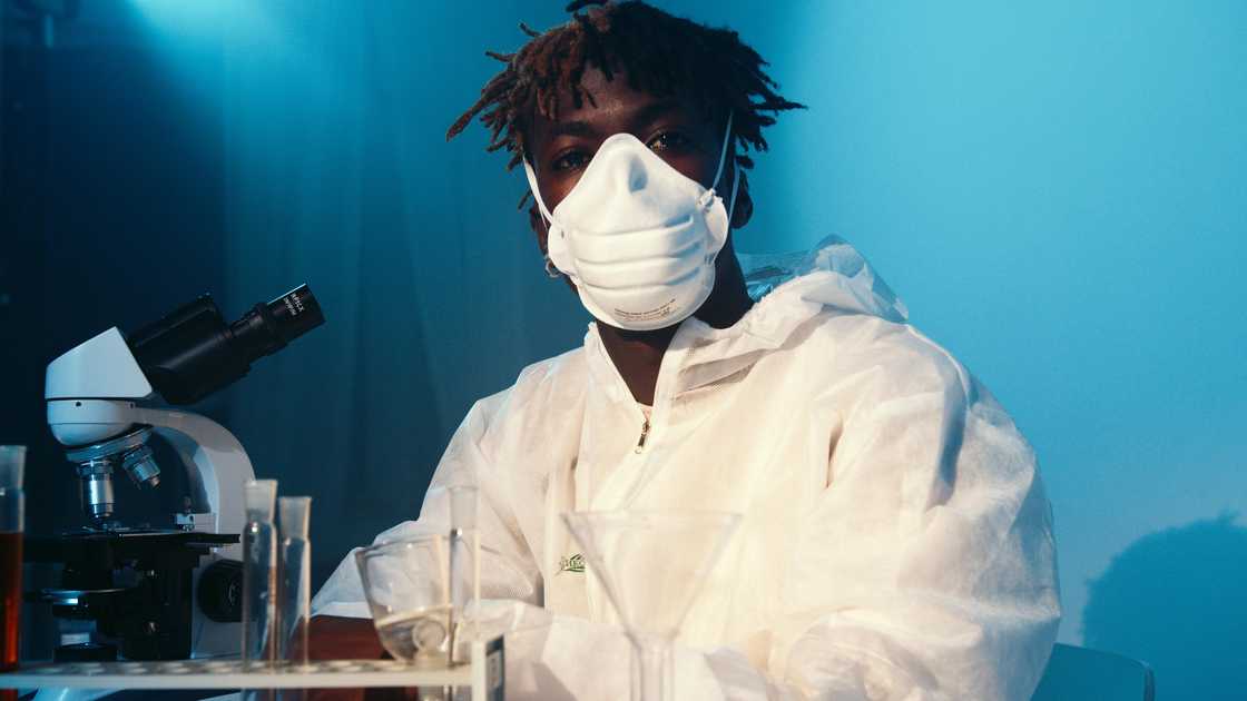 A man wearing protective gear and mask in a lab