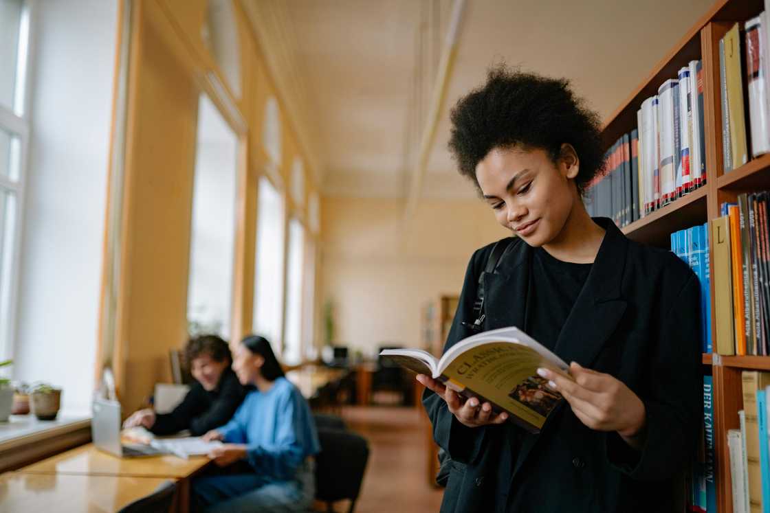 A student reading a book in a library