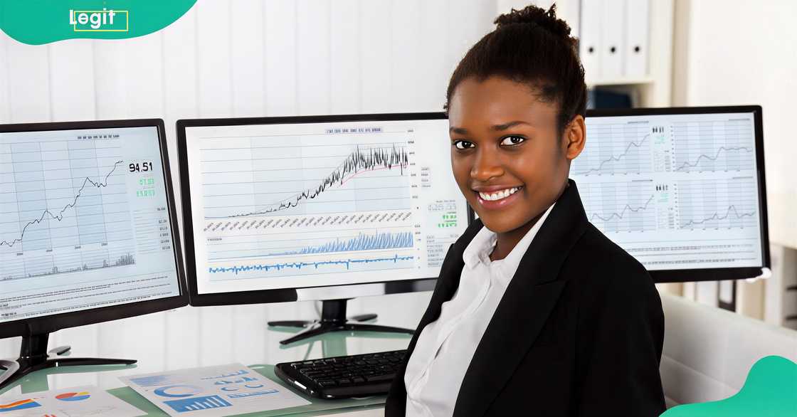 A female professional poses sitting surrounded by monitors displaying data and charts. A female professional poses sitting surrounded by monitors displaying data and charts.