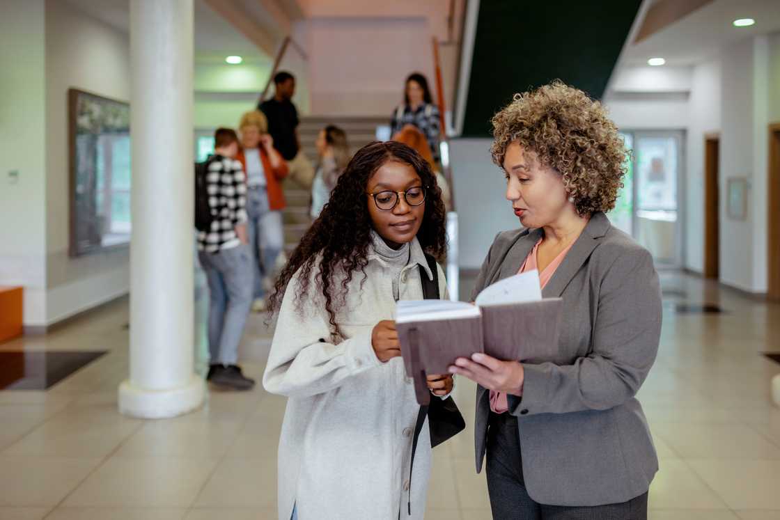 A headteacher discussing documents with a parent.