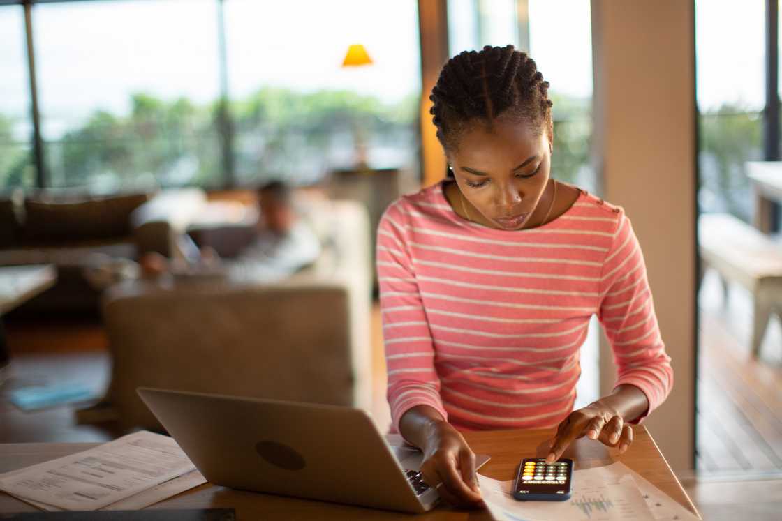 A young woman working on home finances. A young woman working on home finances.