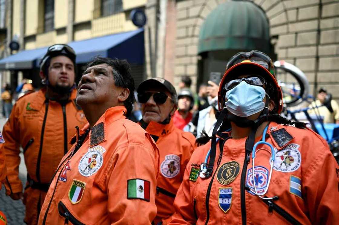 Rescue workers look at damage to a building in Mexico City after a powerful earthquake