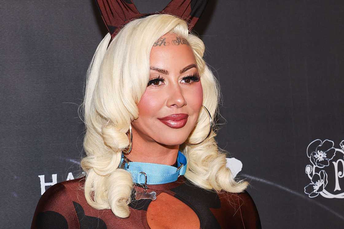 Amber Rose wears a blonde curly wig with bunny ears and a blue collar at a Halloween event.