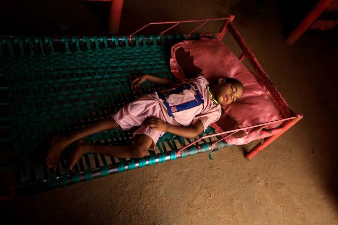 Talab, the youngest child of Awadya Ahmed, lies on a bed in the village of Banat in River Nile state, north of the Sudanese capital Khartoum. She says Talab was born after mining residues spread in the area Talab, the youngest child of Awadya Ahmed, lies on a bed in the village of Banat in River Nile state, north of the Sudanese capital Khartoum. She says Talab was born after mining residues spread in the area