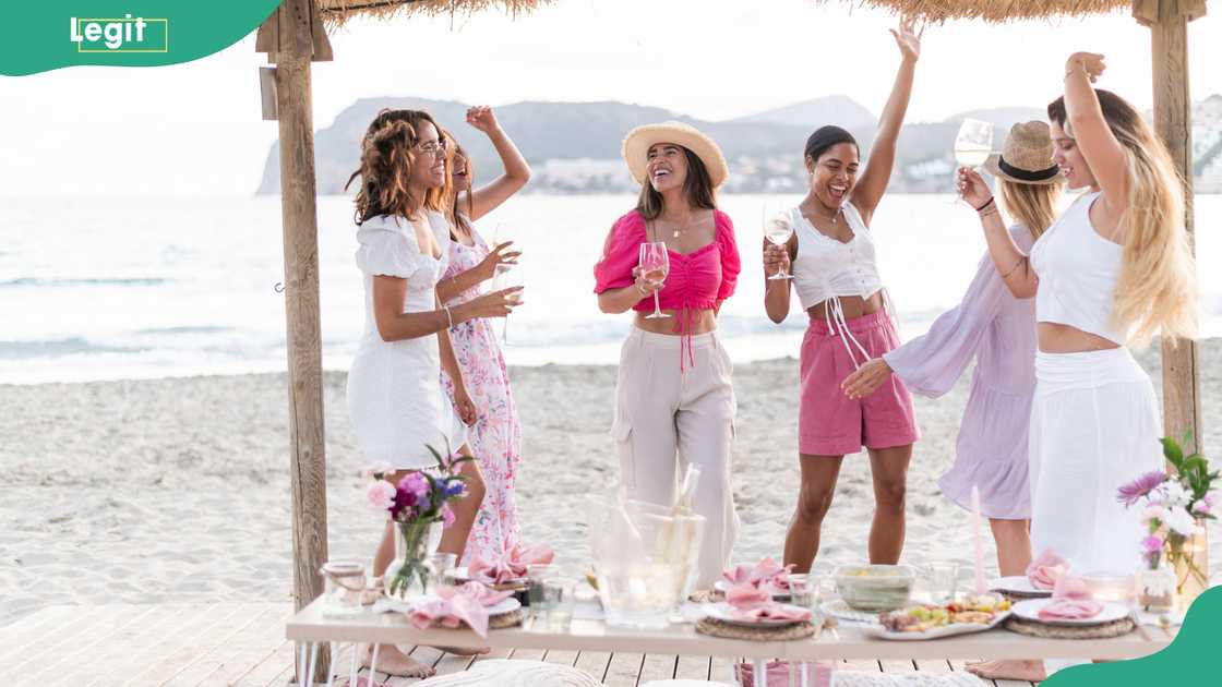 Women raising arms and dancing on a beach Women raising arms and dancing on a beach