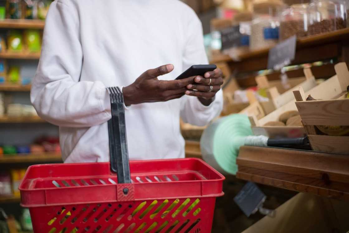 A young man stares at his phone at the supermarket. A young man stares at his phone at the supermarket.
