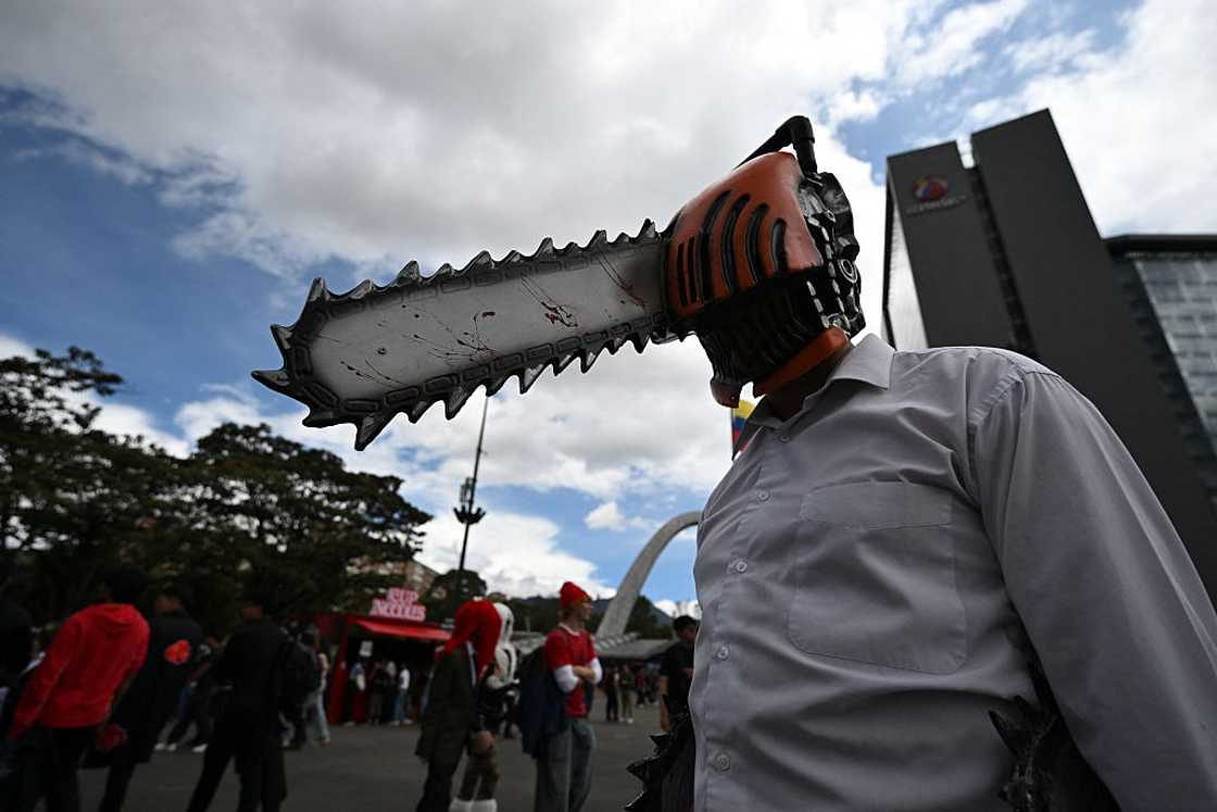 A cosplayer in a Chainsaw Man costume with a chainsaw-shaped helmet, posing outdoors at the SOFA fair in Bogotá, 2026