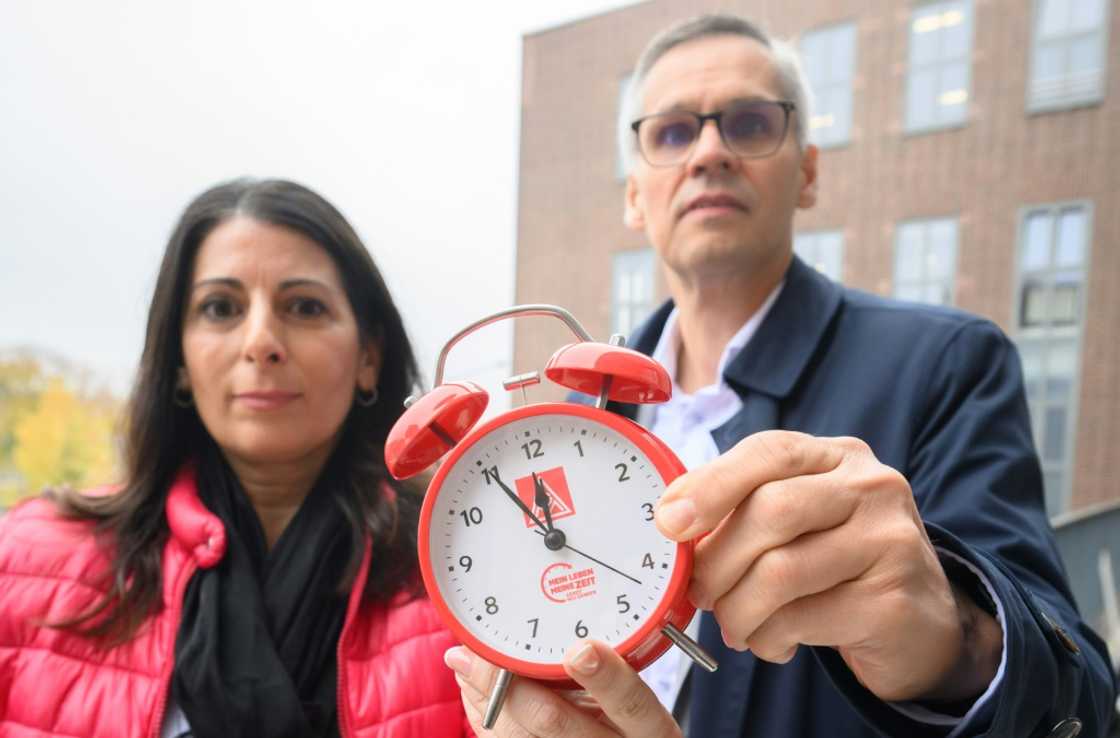 An alarm clock warning it's 'five minutes to high noon' at VW, held up by works council chief Daniela Cavallo and metalworkers union negotiator Thorsten Groeger