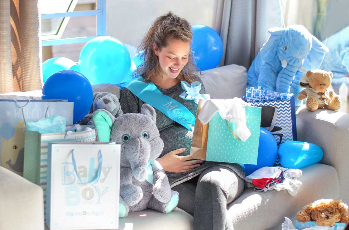 A woman holding her belly at her baby shower A woman holding her belly at her baby shower