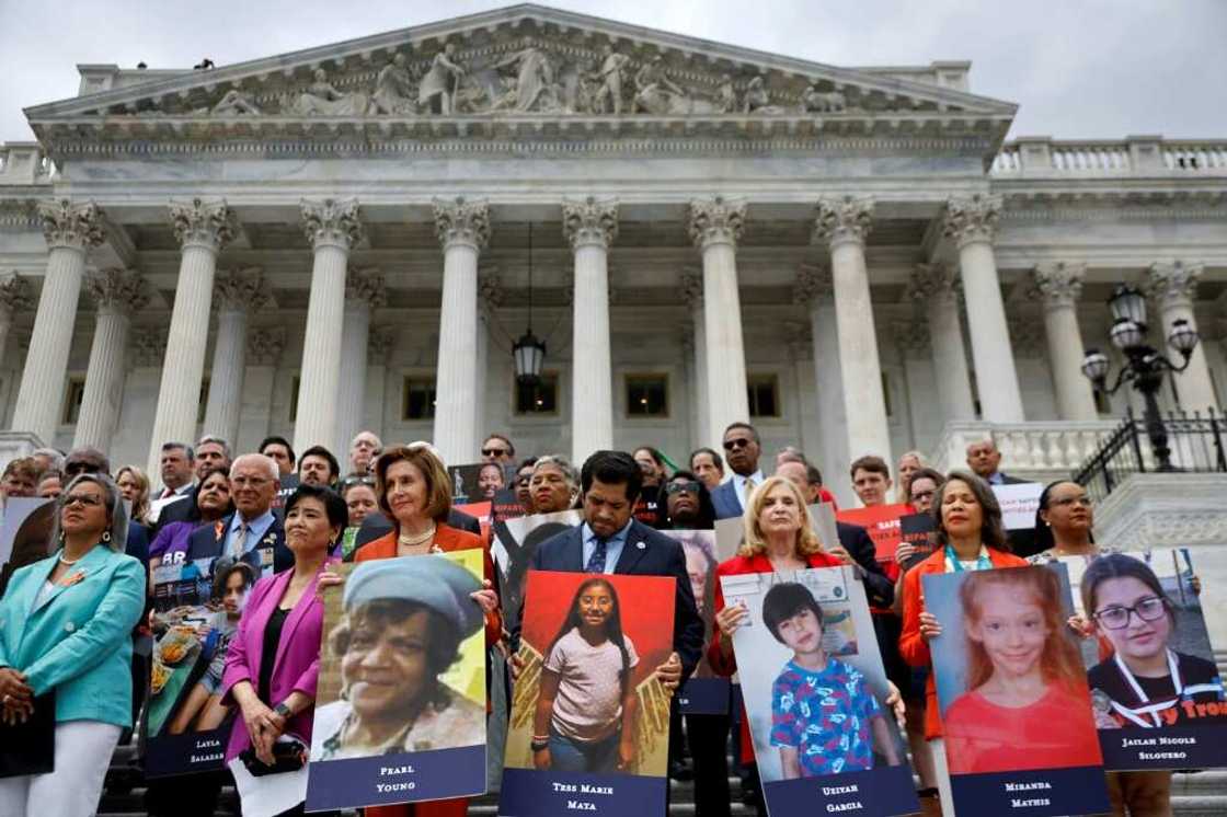 Speaker of the House Nancy Pelosi stands with fellow Democrats holding photographs of the victims of the mass shootings in Buffalo, New York and Uvalde, Texas, before passing the Bipartisan Safer Communities Act in front of the House of Representatives on June 24, 2022