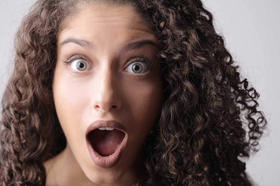 Close-up of a shocked woman with wide eyes and an open mouth. Close-up of a shocked woman with wide eyes and an open mouth.