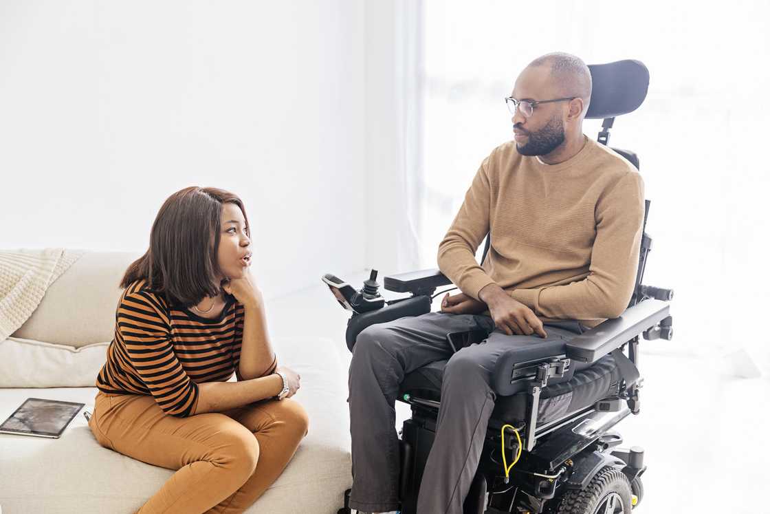 A man in his wheelchair and the wife besides him A man in his wheelchair and the wife besides him