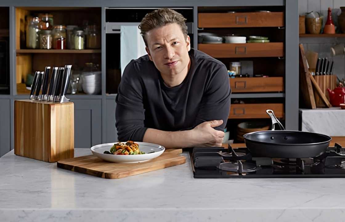 Jamie Oliver poses leaning on a kitchen countertop Jamie Oliver poses leaning on a kitchen countertop