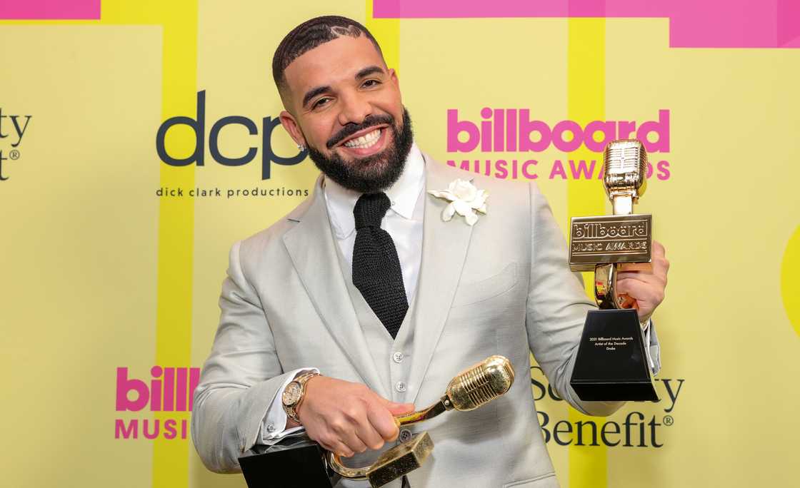 Drake poses backstage with two awards for the 2021 Billboard Music Awards
