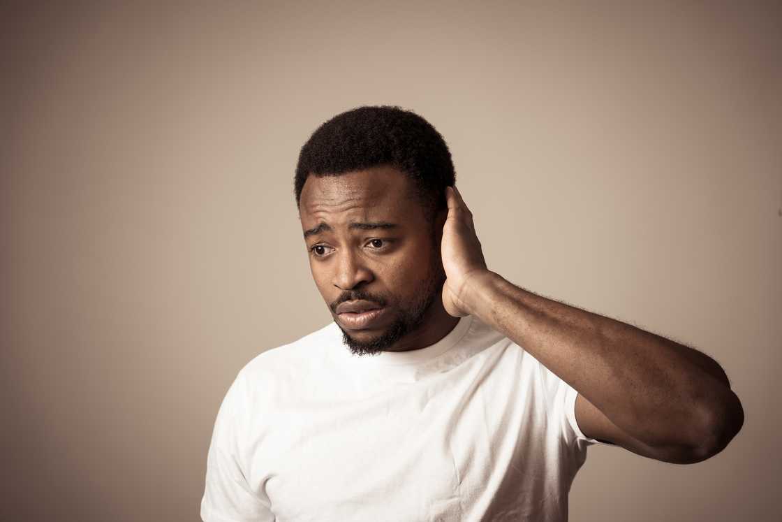 An ashamed man rubbing his head