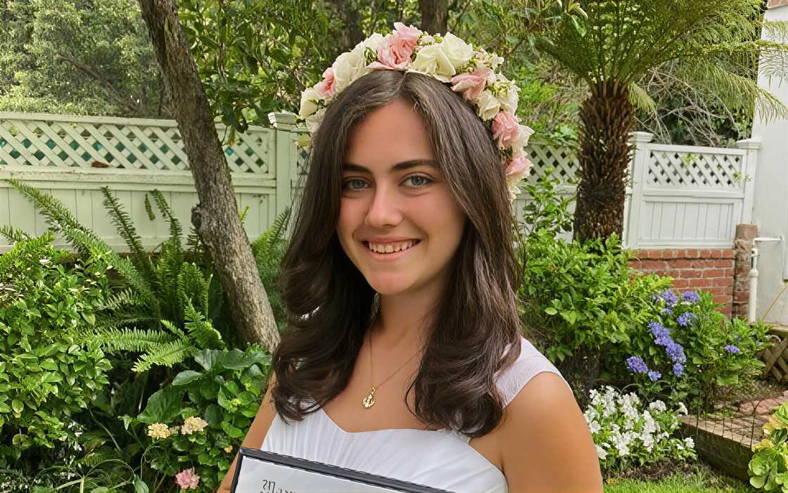 Porter Stracke's daughter poses outdoors after her graduation ceremony