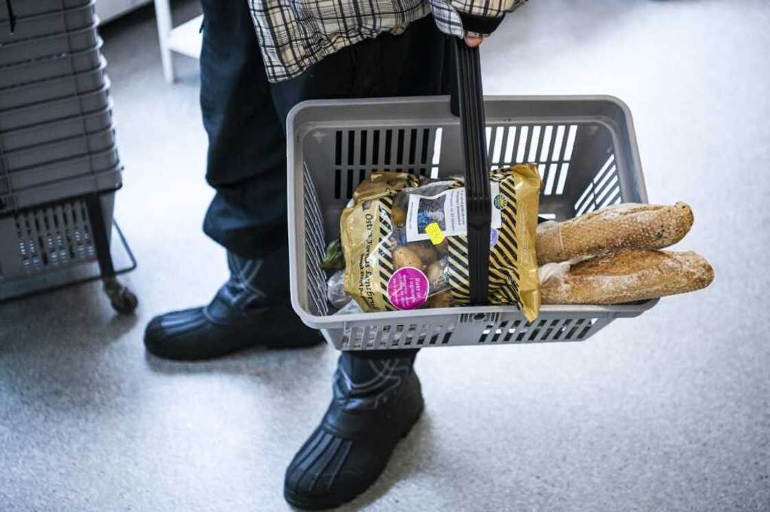 Bread and potatoes: a   man buys food at a cut-price Red Cross shop