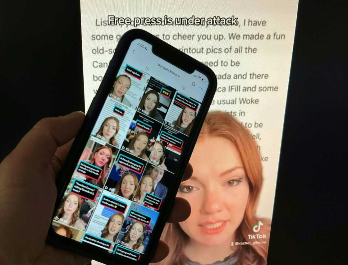 Photo illustration created December 15, 2022, in Washington, DC, shows a person holding up the TikTok feed of Canadian journalist Rachel Gilmore against the backdrop of one of her online posts. Photo illustration created December 15, 2022, in Washington, DC, shows a person holding up the TikTok feed of Canadian journalist Rachel Gilmore against the backdrop of one of her online posts.