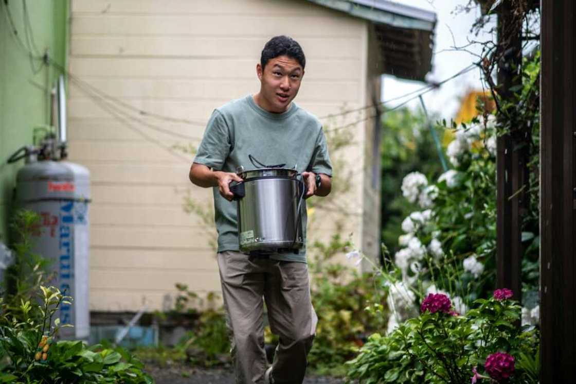 Koichi Miyatsu, 18, carries a pot from his home to a church as part of a monthly charity event for underprivileged children Koichi Miyatsu, 18, carries a pot from his home to a church as part of a monthly charity event for underprivileged children