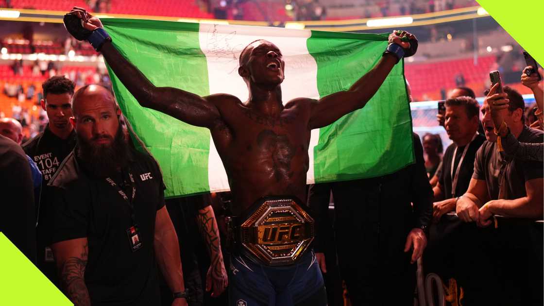 Israel Adesanya holds the Nigerian flag after beating Alex Pereira at UFC 287.