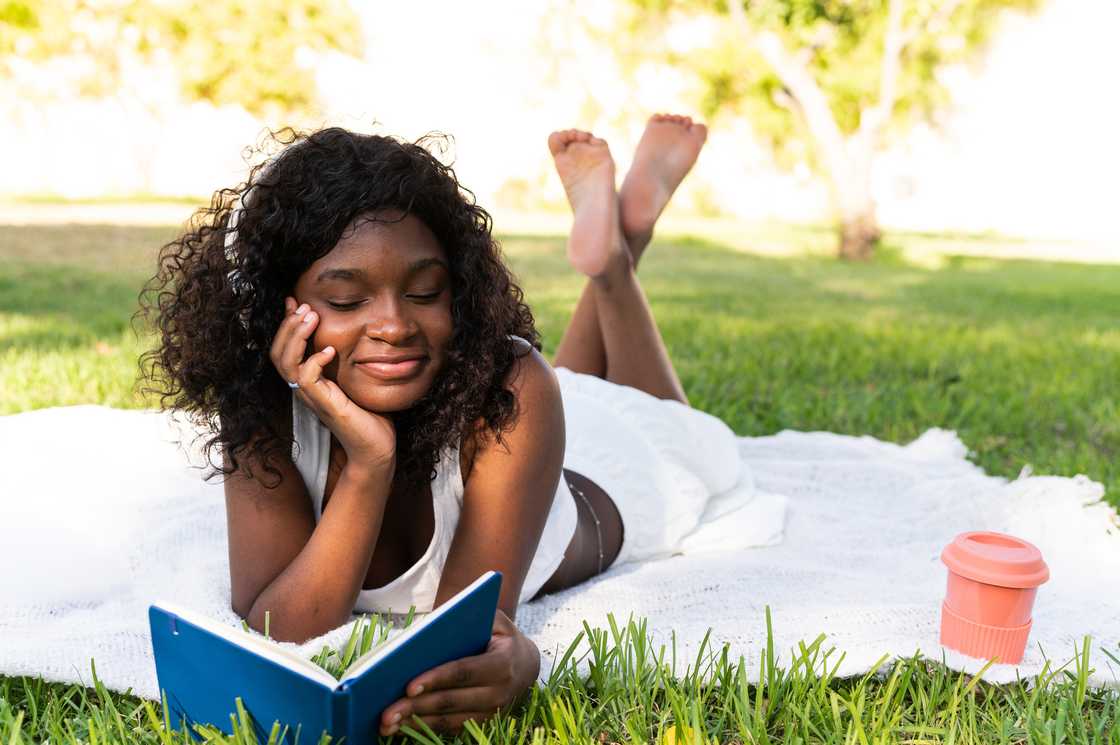 Girl studying happily under a tree after school. Girl studying happily under a tree after school.