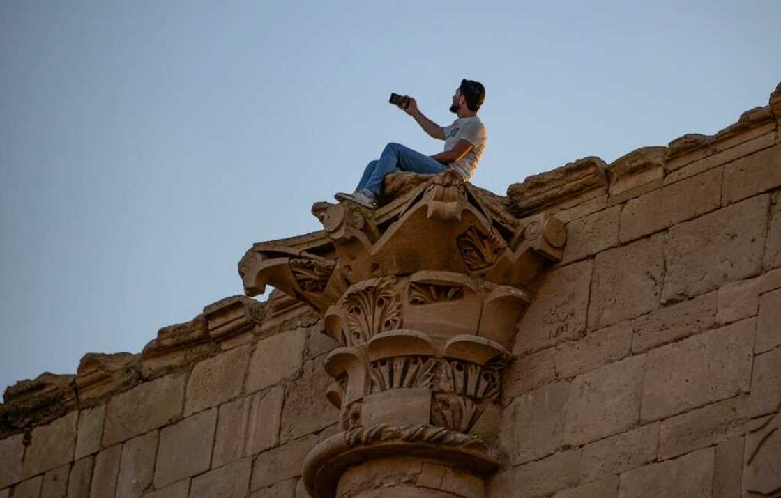 The tourists were taking selfies in front of impressive colonnades with Corinthian capitals The tourists were taking selfies in front of impressive colonnades with Corinthian capitals