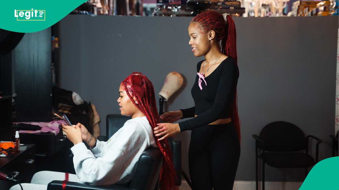 A hairstylist braid's her client's hair