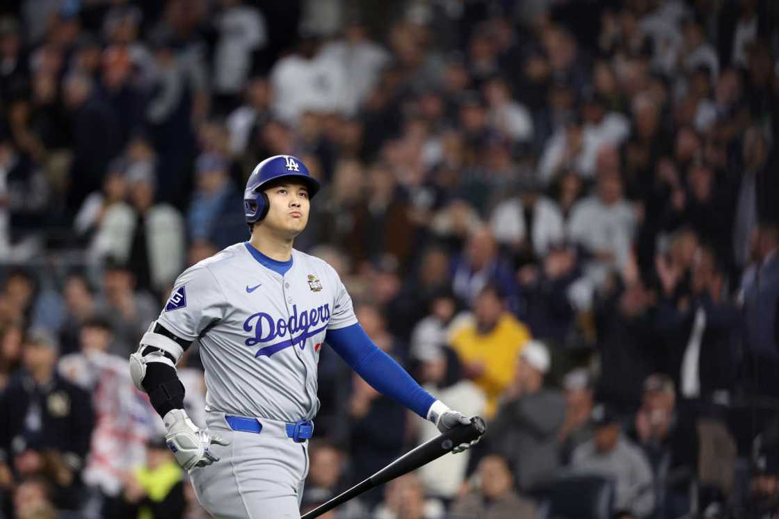 Shohei Ohtani in the Los Angeles Dodgers jersey holding a bat Shohei Ohtani in the Los Angeles Dodgers jersey holding a bat