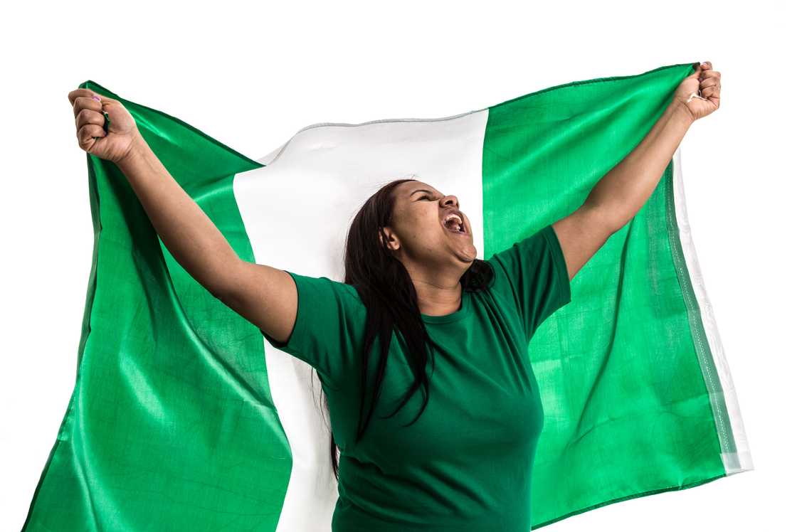 Nigerian lady holding the national flag.