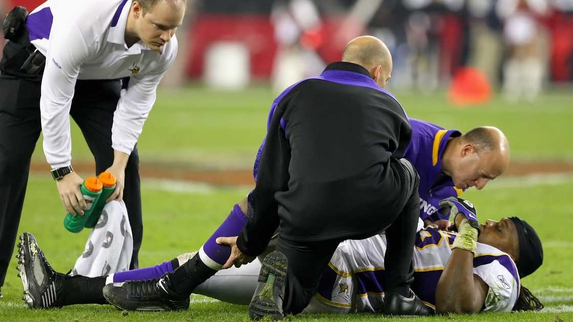 Minnesota Vikings' linebacker E.J. Henderson lies on the ground and is attended to by medical staff after an injury.