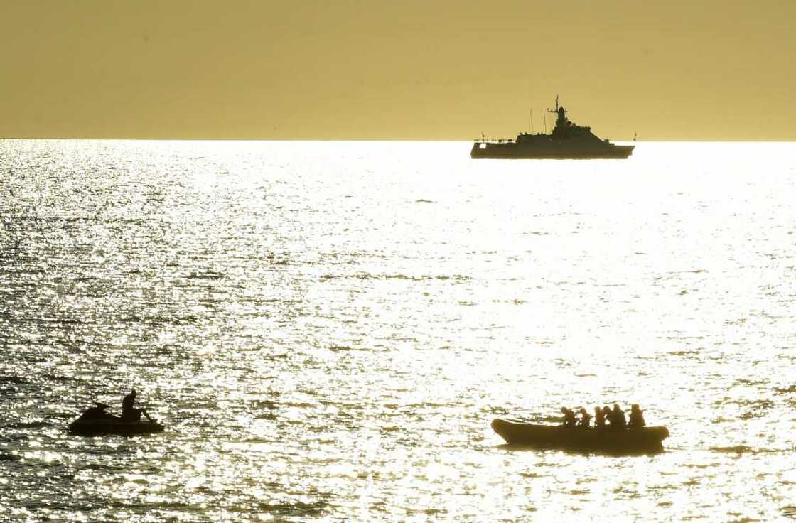 In Sevastopol, Crimea's largest city and home to the Russian Black Sea fleet, Russian warships are visible as beachgoers cool off in the sea In Sevastopol, Crimea's largest city and home to the Russian Black Sea fleet, Russian warships are visible as beachgoers cool off in the sea