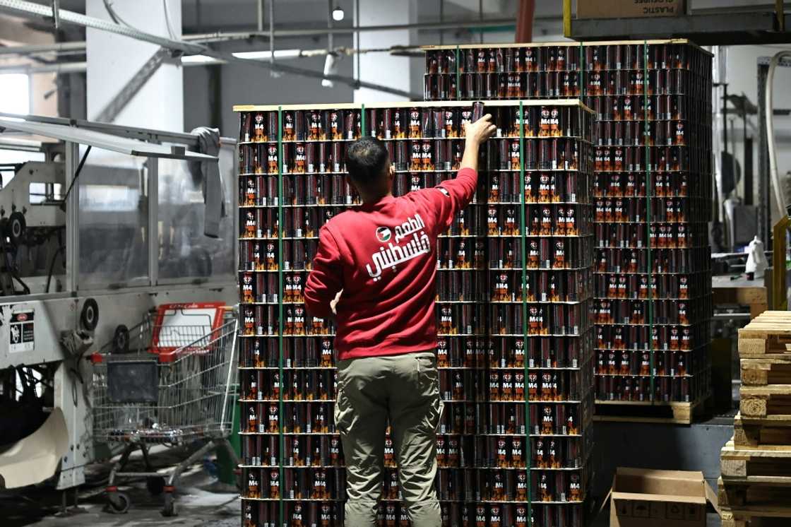 Factory workers wear sweaters emblazoned with the words 'Palestinian taste' in Arabic Factory workers wear sweaters emblazoned with the words 'Palestinian taste' in Arabic