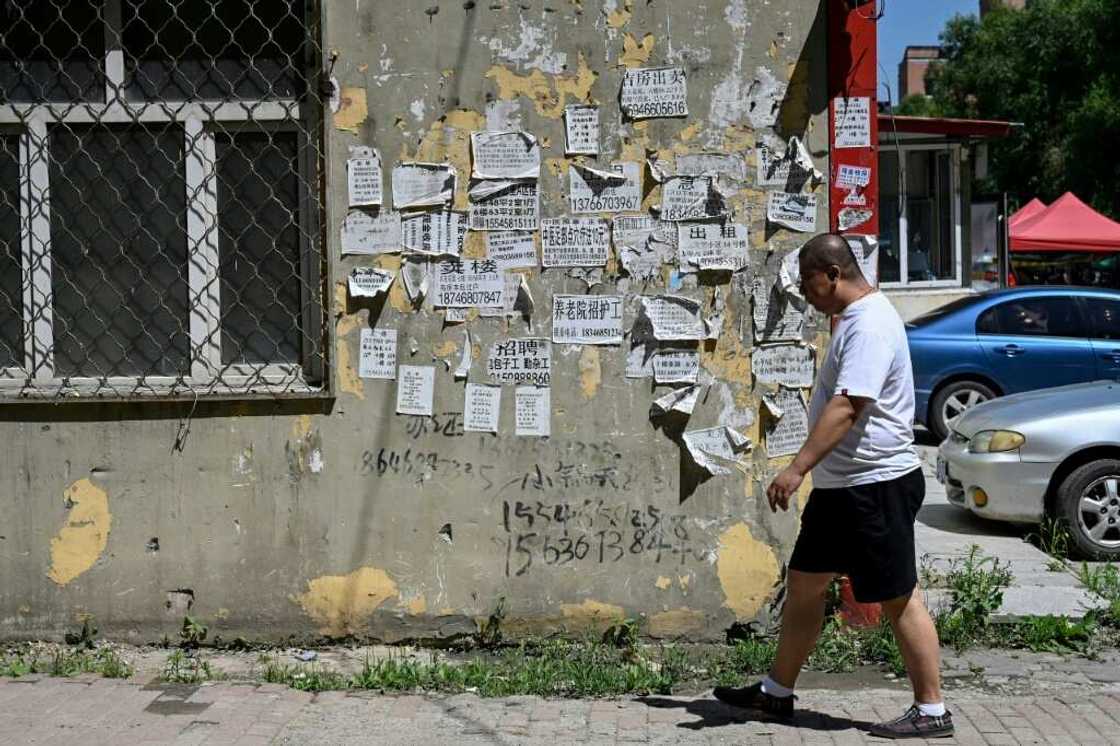 A man walks past home rental advertisements in a residential compound in Hegang city in northeastern China's Heilongjiang province A man walks past home rental advertisements in a residential compound in Hegang city in northeastern China's Heilongjiang province