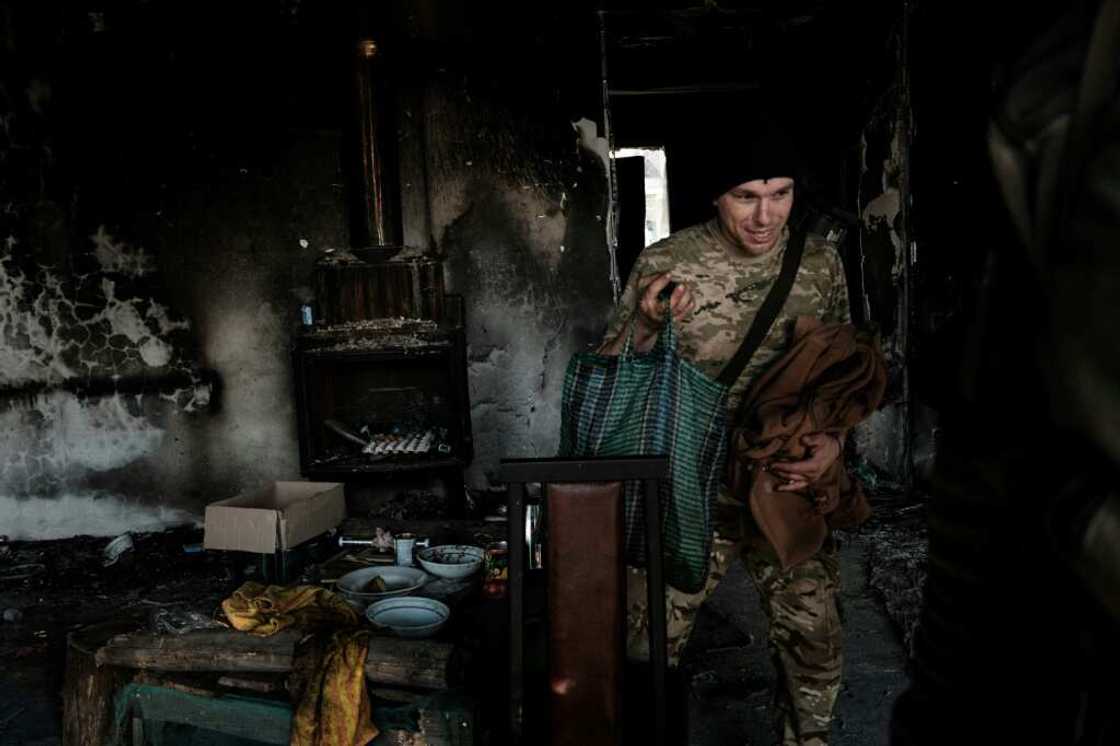 A Ukrainian soldier leaves the burnt-out house where he stayed with his unit A Ukrainian soldier leaves the burnt-out house where he stayed with his unit