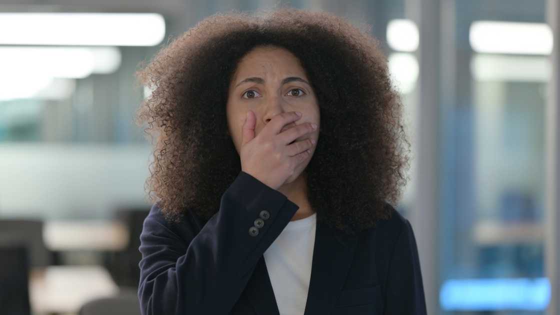 A terrified woman holding her mouth A terrified woman holding her mouth