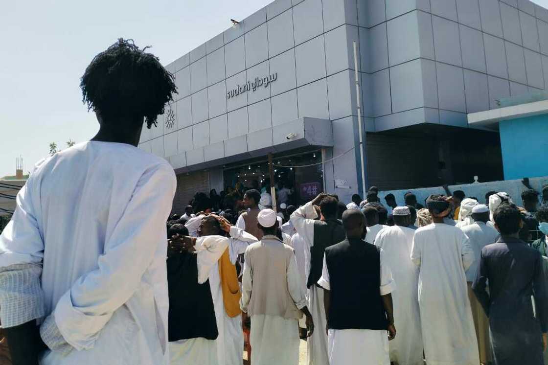 Sudanese in the eastern city of Kassala queue on February 18, 2024 outside the Sudani telecommunications company to get SIM cards from the only provider still functioning