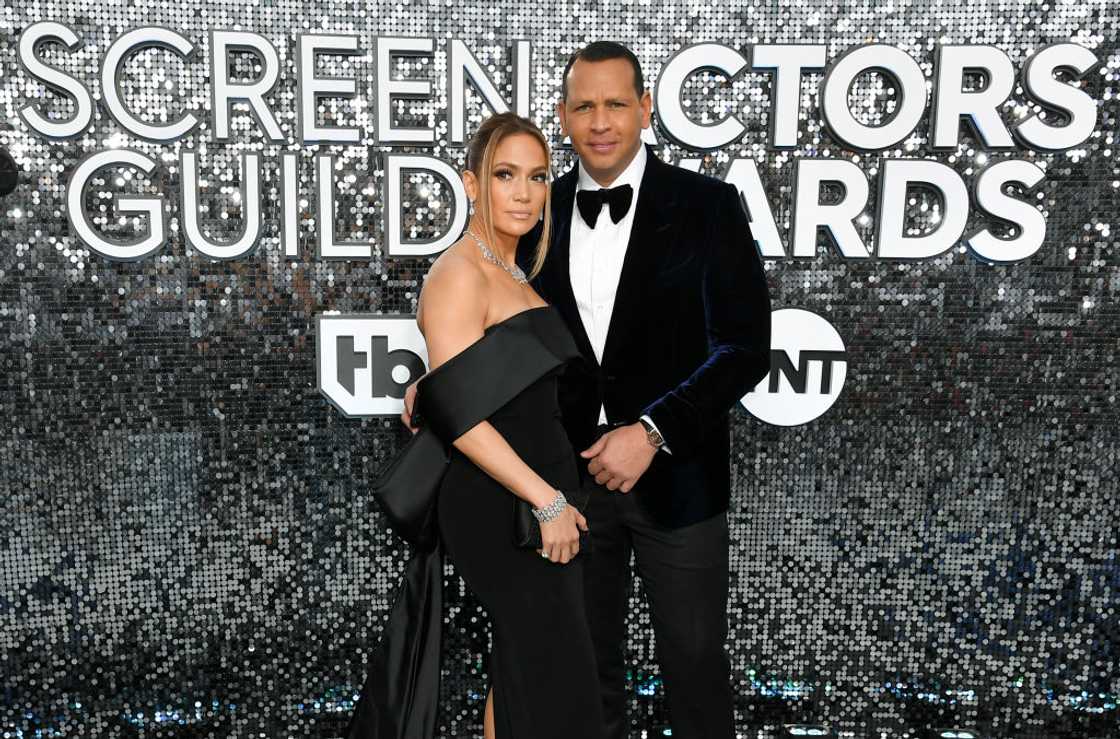 Jennifer Lopez in a black off-shoulder gown beside Alex Rodriguez in a navy velvet tuxedo jacket. Jennifer Lopez in a black off-shoulder gown beside Alex Rodriguez in a navy velvet tuxedo jacket.