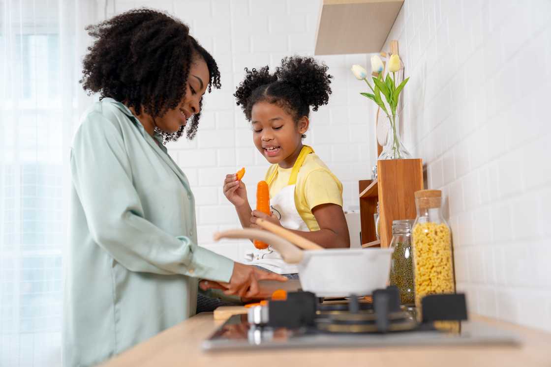 Mom and daughter have fun cooking in the kitchen. Mom and daughter have fun cooking in the kitchen.