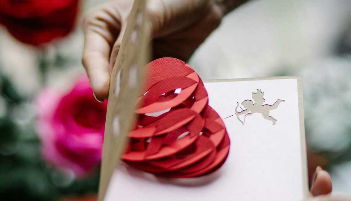 A card with a red heart and cupid shooting arrow