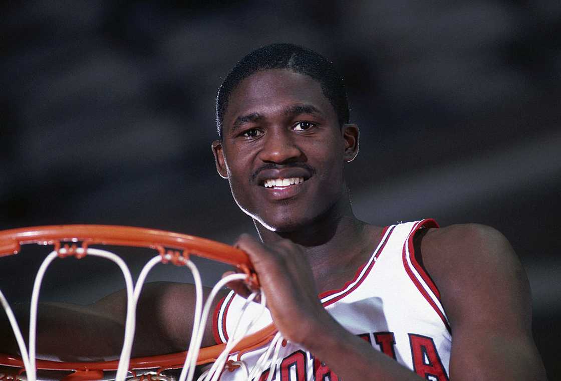 Dominique Wilkins poses for a photo above the net