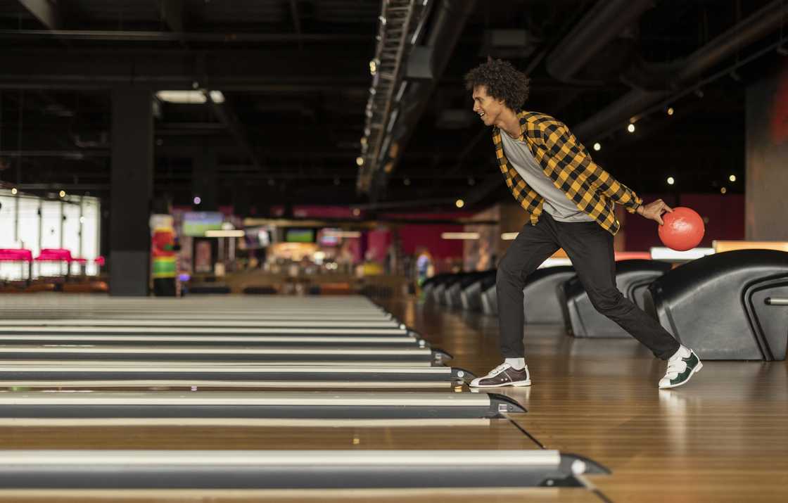 Young man throwing ball at bowling alley