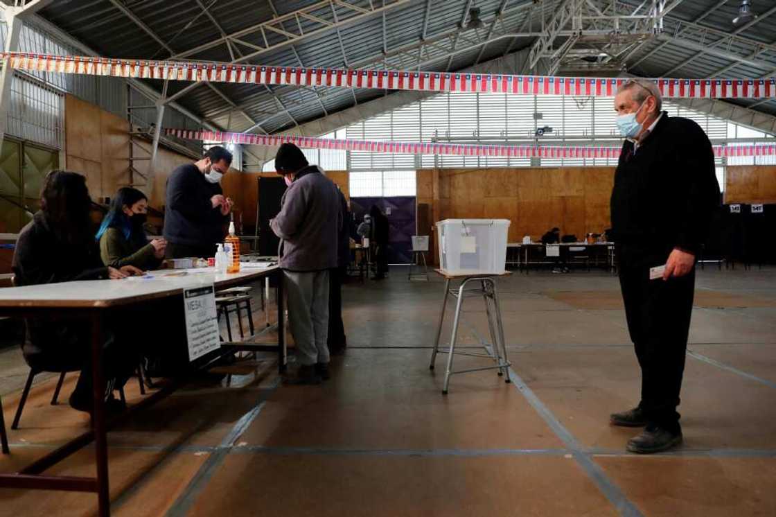 A man waits in line to cast his vote during a referendum to approve or reject a new Constitution at a polling station in Santiago