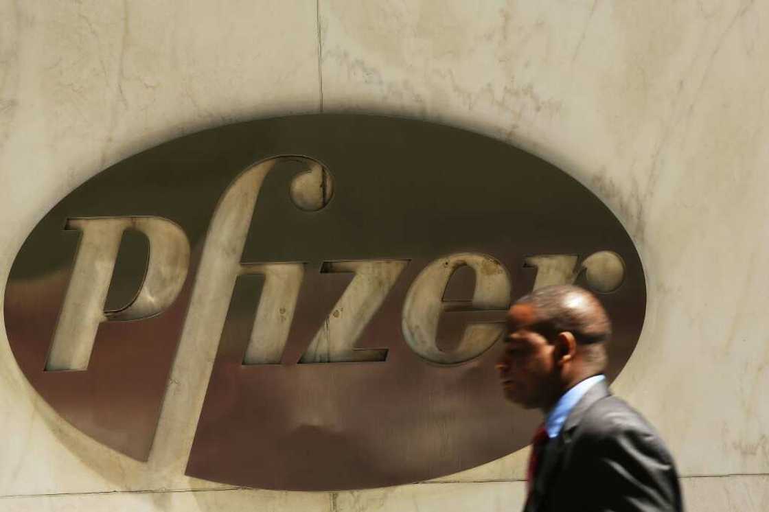 A man walks past the Pfizer logo on the drug maker's headquarters in New York A man walks past the Pfizer logo on the drug maker's headquarters in New York