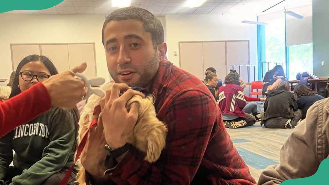 Adan Correa cuddles a puppy