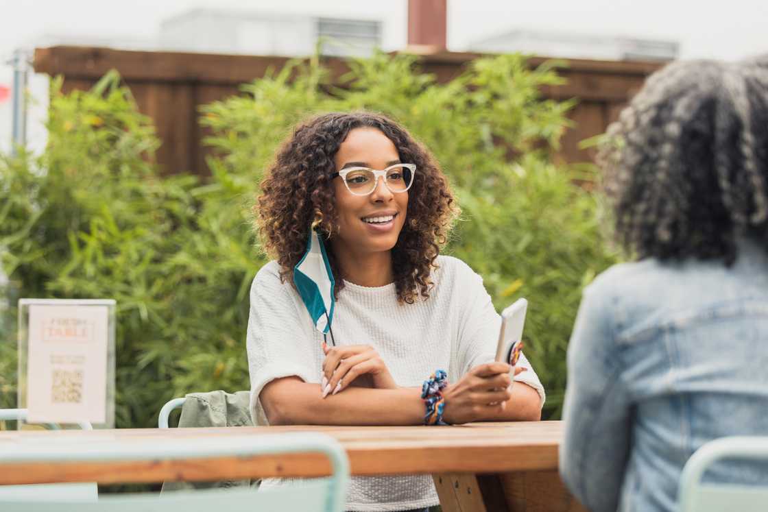 Two women sitting on a the patio of a restaurant. Two women sitting on a the patio of a restaurant.